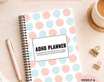 Puede incluir: Un planificador de TDAH con espiral con una cubierta con lunares rosas y azules. El planificador incluye el texto "ADHD PLANNER" y "Productividad para el cerebro TDAH: estrategias semanales y diarias."