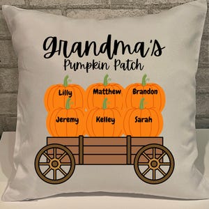May include: A decorative pillow with the text "grandma's Pumpkin Patch" above a wooden cart filled with orange pumpkins. Each pumpkin has a name: Lilly, Jeremy, Matthew, Kelley, Brandon, and Sarah. The pillow is white.