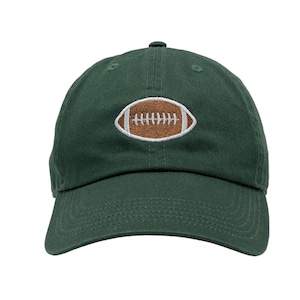 May include: A dark green baseball cap with a brown and white embroidered football design.