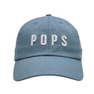 May include: A blue baseball cap with the word "POPS" embroidered in white on the front.