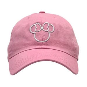 May include: Pink baseball cap with a white embroidered outline of Minnie Mouse's head with a bow.
