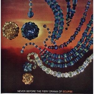 May include: An advertisement for Laguna Crown Jewel jewellery. The image features necklaces, earrings, and brooches in shades of blue, green, and gold. The text reads "NEVER BEFORE THE FIERY DRAMA OF ECLIPSE".