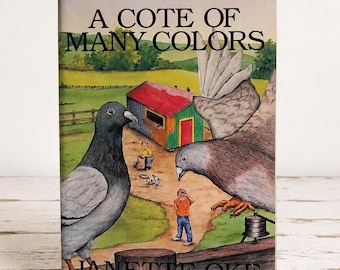 May include: A hardcover book titled A Cote of Many Colors by Janette Oke. The cover features an illustration of two grey pigeons, a small colorful coop, and two children in a grassy field. The text A Classic Children's Story appears at the top.
