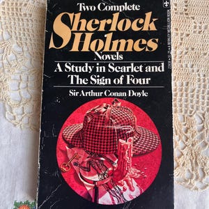 May include: A set of three ceramic mugs with a speckled, cream-colored glaze. Each mug features a different hand-painted floral design in shades of blue, green, and yellow. The mugs have a simple, rounded shape and a comfortable handle.