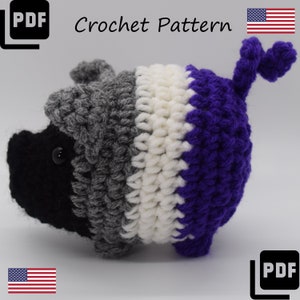 May include: Crochet pattern for a grey, white and purple pig. The pig has a black nose and eyes. The pattern is available as a PDF download.