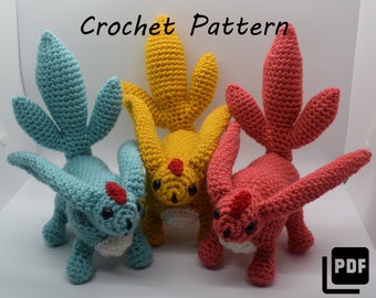 May include: Three crocheted creatures in blue, yellow, and red, each with multiple tail-like appendages and a red marking on their foreheads. The text "Crochet Pattern" is at the top of the image. A PDF icon is in the bottom right corner.