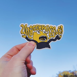 May include: A yellow cartoon character with a black shirt and a large mouth shouting "Unacceptable!" in a yellow bubble. The character is holding its arms out to the sides.