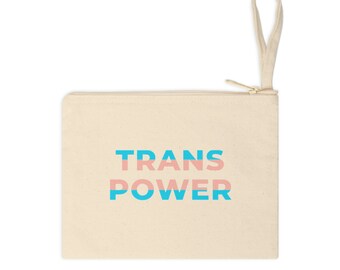Puede incluir: Una bolsa de lona beige con cremallera y asa superior. La bolsa tiene las palabras "TRANS POWER" impresas en azul y rosa.