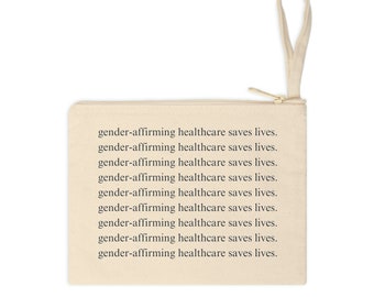 Puede incluir: Una bolsa de lona beige con cremallera y una correa blanca. La bolsa tiene el texto "gender-affirming healthcare saves lives" repetido nueve veces.