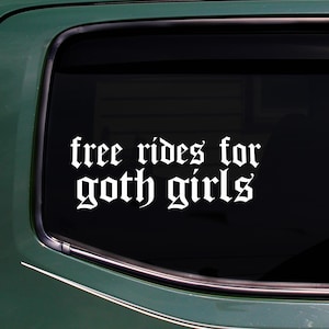 May include: White vinyl decal with the text "free rides for goth girls" in a gothic font, applied to a car window. The decal is displayed against a dark background.