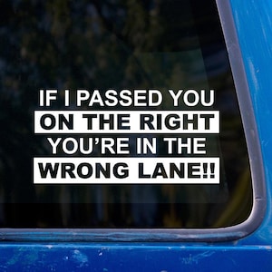 May include: A white sticker on a blue car window reads: "If I passed you on the right you're in the wrong lane!!"