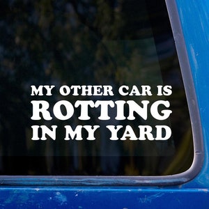 May include: A white vinyl sticker on a blue car window that reads "My other car is rotting in my yard."