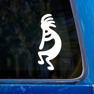 Puede incluir: Adhesivo blanco de la figura de Kokopelli en la ventana azul de un vehículo. Kokopelli, símbolo nativo americano de fertilidad y música, se muestra en forma estilizada con una flauta y un tocado.