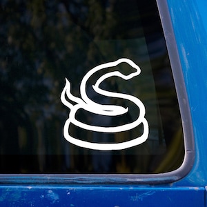 Pode incluir: Adesivo de vinil branco de uma cobra enrolada com a cabeça levantada em uma janela de carro azul.