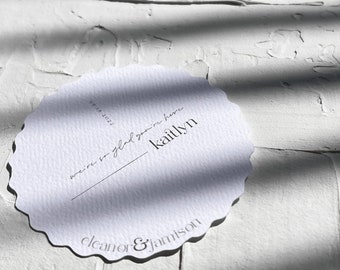 Könnte beinhalten: Weiße, gewellte Karte mit schwarzem Text. Der Text lautet "We're so glad you're here" und "Kaitlyn" mit dem Datum "07.18.2022" darüber. Unter dem Text steht "Eleanor & Jamison".