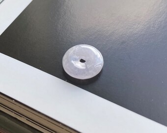 May include: A light lavender jade pendant in the shape of a circle with a hole in the center.