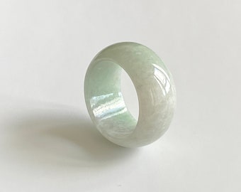 May include: A light green jade ring with a smooth, polished surface.