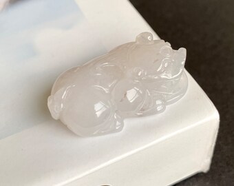 May include: A white jade carving of a pig, a traditional Chinese symbol of good luck and prosperity.