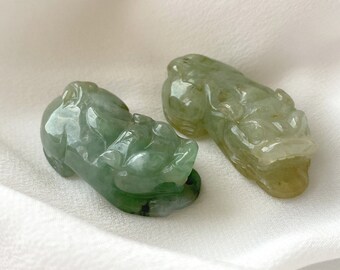 May include: Two jade green Chinese dragon figurines. The dragons are carved in a detailed, realistic style and have a glossy finish.