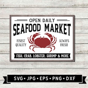 Op de afbeelding: Een wit bord met zwarte tekst dat "Open Daily Seafood Market" zegt met een rode krabillustratie in het midden. Het bord zegt ook "Finest Quality" en "Always Fresh" en "Fish, Crab, Lobster, Shrimp & More".