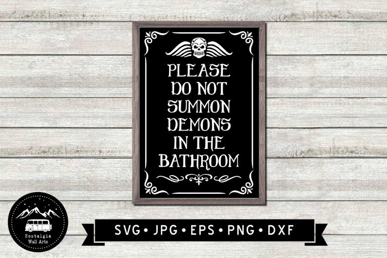 May include: A black and white sign with a skull and wings graphic and the text "PLEASE DO NOT SUMMON DEMONS IN THE BATHROOM". The sign is framed in a dark wood frame.
