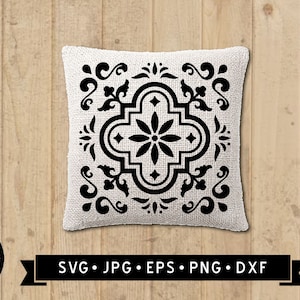 May include: Black and white cushion with a geometric pattern. The pattern features a central flower design with four surrounding squares. The cushion is on a wooden background.