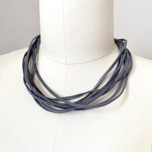 Grijze imitatiesuède touwketting: minimalistisch textielontwerp