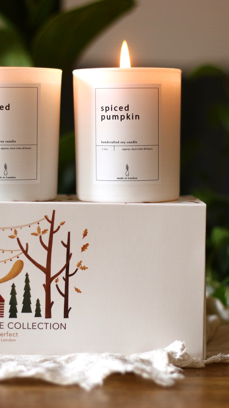 Puede incluir: Dos velas de soja blancas con etiquetas. La vela de la izquierda est&aacute; etiquetada como "ed" y la vela de la derecha est&aacute; etiquetada como "spiced pumpkin". Ambas velas son velas de soja artesanales y tienen un tiempo de combusti&oacute;n de aproximadamente 40 horas. Las velas est&aacute;n sobre una caja blanca con una escena de bosque impresa en ella. La caja est&aacute; etiquetada como "The Collection" y "Perfect London".