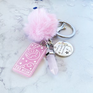 Peut inclure: Porte-cl&eacute;s en fourrure rose avec un charme de carte de tarot rose qui dit "The Moon", un charme de cristal rose et un charme argent&eacute; qui dit "I love you to the moon & back".