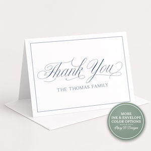 Może przedstawiać: Biała składana kartka z granatową ramką oraz napisem "Thank You" wykonanym kursywą, pod którym znajduje się tekst "THE THOMAS FAMILY" czcionką szeryfową. Okrągła szałwiowa plakietka zawiera napis "MORE INK & ENVELOPE COLOR OPTIONS" oraz "Mary B Designs".