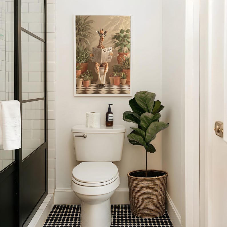 a bathroom with a toilet, a framed picture of a giraffe reading a newspaper, and a potted plant.