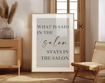 May include: A rectangular framed wall art print featuring a light gray background with black text that reads: WHAT IS SAID IN THE salon STAYS IN THE SALON. The print is displayed in a thin wooden frame, showcasing a mix of serif and script fonts.