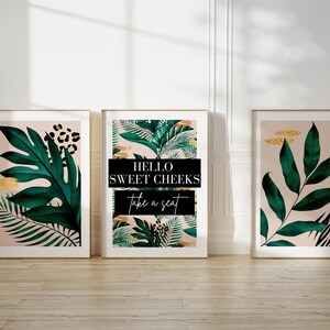 three framed prints of tropical plants, including leopard leaves, arranged on a white wall.