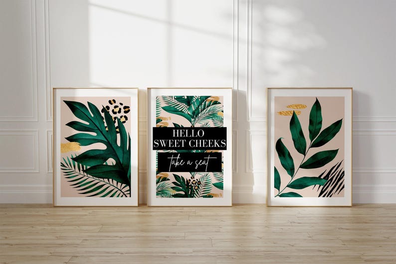 three framed prints of tropical plants, including leopard leaves, arranged on a white wall.