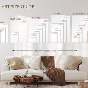 a wall art size guide for various wall art sizes, including 3/4' and 5/8'ratio, as well as a sofa size guide. The guide provides measurements for different sizes, such as 11/14'inch, 4/5'ratio, 23'ratio, and 57'ratio (A1A4). The living room setting includes a couch, a coffee table, and a lamp, creating a cozy and inviting atmosphere.