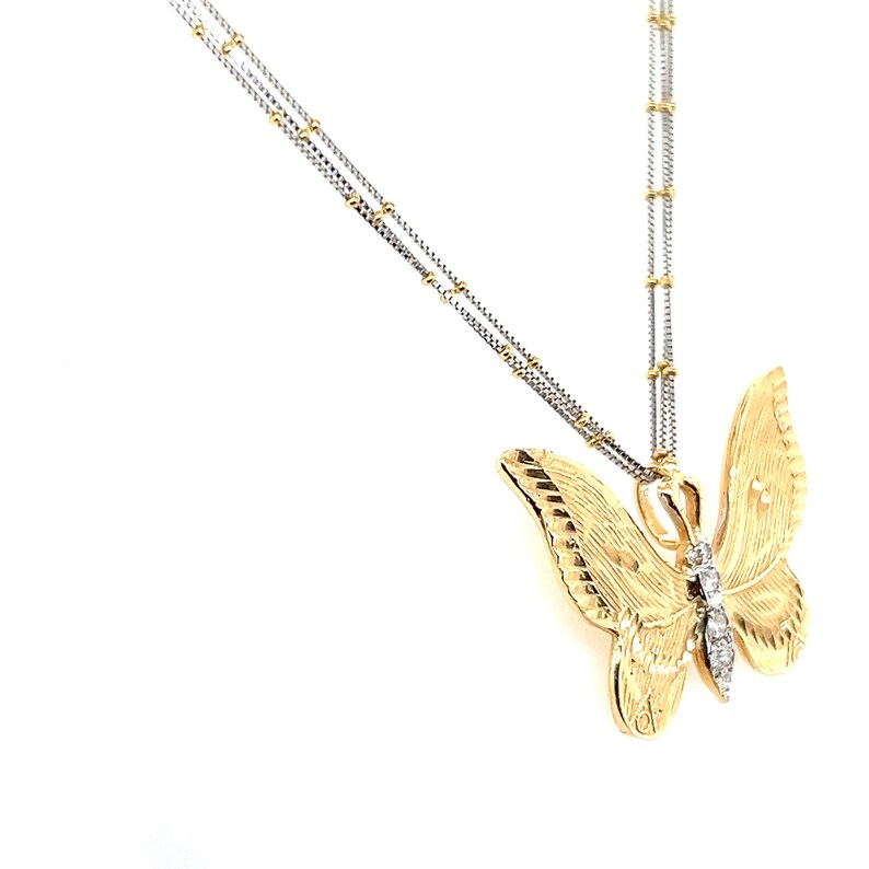May include: A gold-coloured butterfly pendant necklace with a textured finish. The butterfly has a diamond accent and hangs from a delicate chain. The necklace is a jewellery item.
