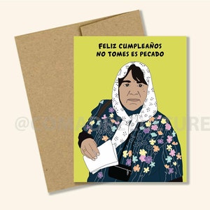 May include: A yellow card with a woman in a blue and white patterned shawl and a white headscarf. The text on the card reads "Feliz cumpleaños no tomes es pecado".