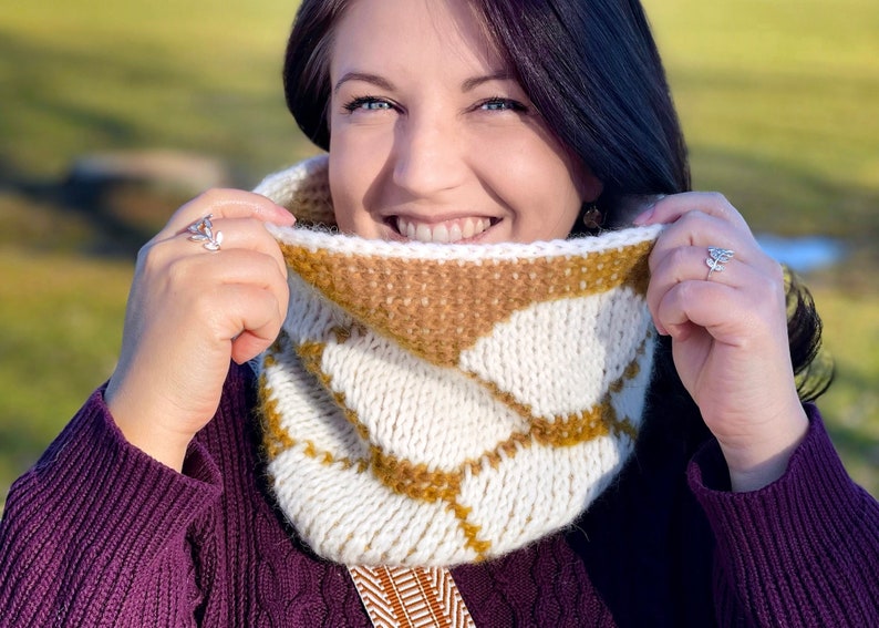 Reversible Cream and Gold Tunisian crochet cowl with hexagon motif, worn by smiling dark haired woman in purple sweater
