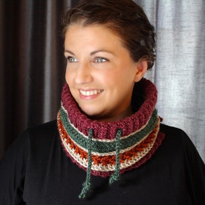 Bright coloured red and green crochet cowl with drawstring modelled on dark haired woman.
