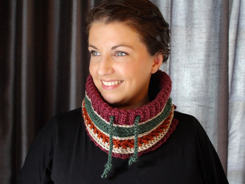 Bright coloured red and green crochet cowl with drawstring modelled on dark haired woman.