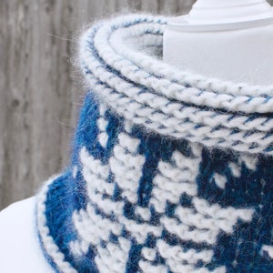 Closeup of Dark Blue reversible Tunisian Crochet Cowl with white snowflake motif on mannequin, viewed from the front.