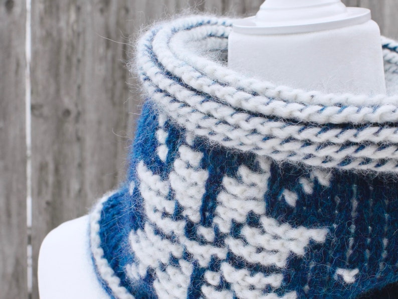 Closeup of Dark Blue reversible Tunisian Crochet Cowl with white snowflake motif on mannequin, viewed from the front.