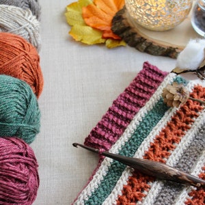 closeup of a red, orange and green crochet cowl as it is being made.