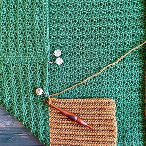 Close up of the Collar of a dark green textured crochet shrug with gold folded over ribbed collar being crocheted.