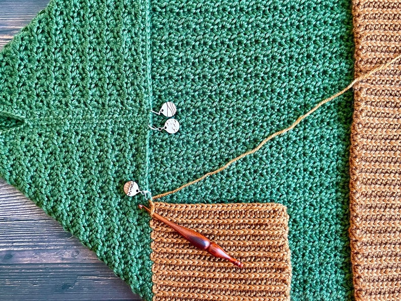 Close up of the Collar of a dark green textured crochet shrug with gold folded over ribbed collar being crocheted.