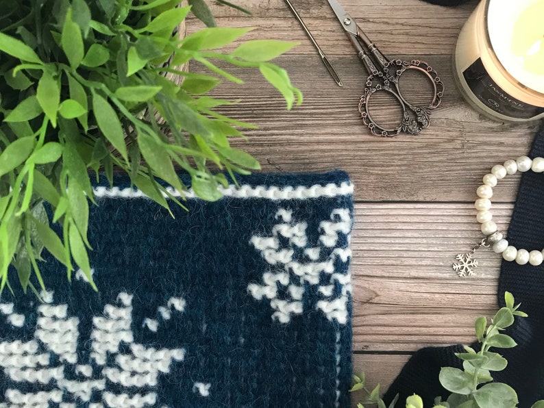 Closeup of corner of dark blue Tunisian Crochet Cowl with white snowflake motif.