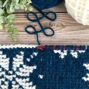 Navy Blue Tunisian Crochet Cowl with white snowflake motif in progress on Tunisian crochet hook.