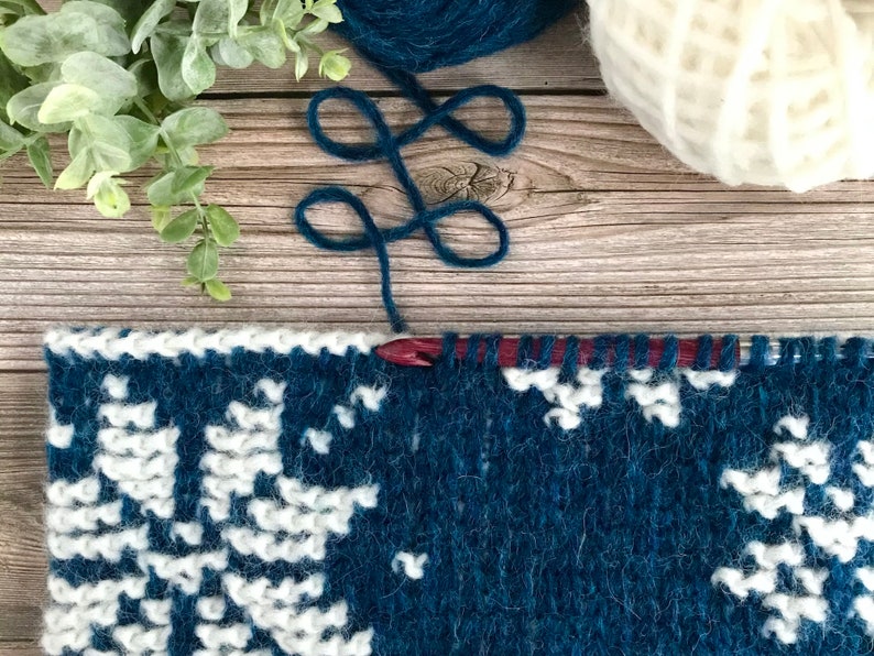 Navy Blue Tunisian Crochet Cowl with white snowflake motif in progress on Tunisian crochet hook.