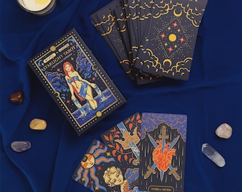 Pode incluir: Um baralho de tarot Starlight com uma caixa ilustrada com uma figura a verter água, um leque de cartas com padrões celestiais e cartas individuais que mostram um sol, uma pessoa com girassóis e um coração atravessado por três espadas.