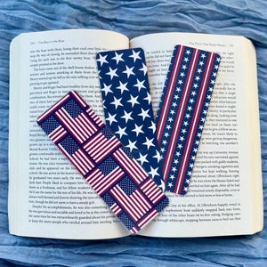 May include: Four different bookmark designs featuring the American flag in red, white, and blue. The bookmarks are made of paper and have a glossy finish.